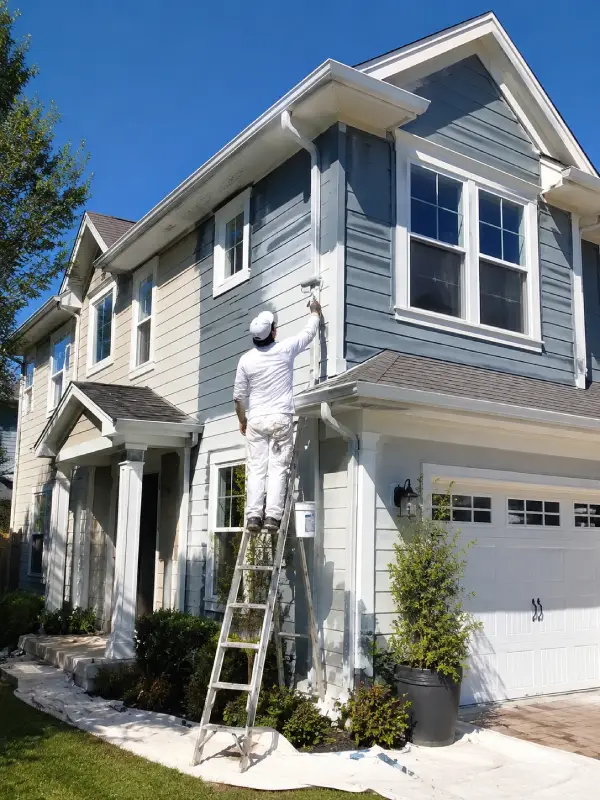 Exterior painting in progress on a residential home to refresh siding and trim with a clean new finish.