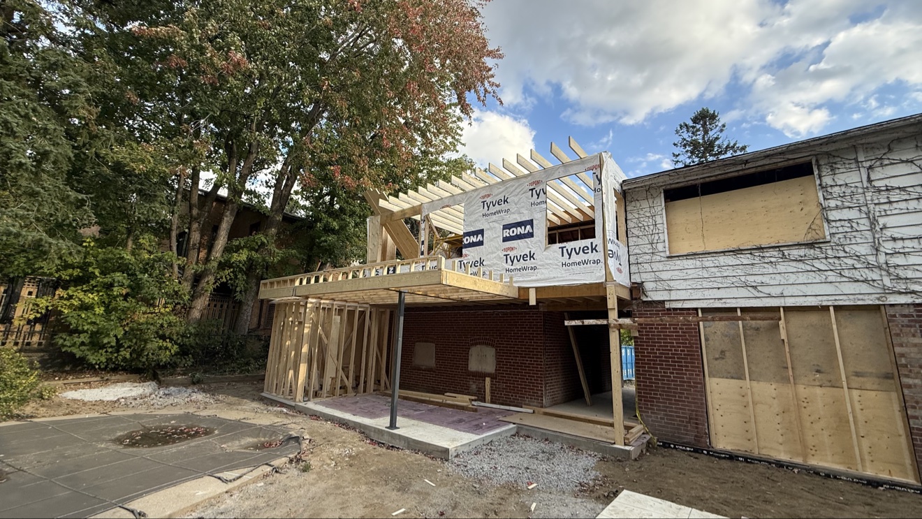 Tyvek-wrapped second-floor addition with roof framing in progress — Rouge Home Development Inc.